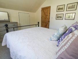 A bedroom with a bed and dresser at Happiness Cottage Piddlehinton