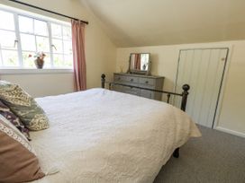 A bedroom with a bed and dresser at Happiness Cottage in Piddlehinton