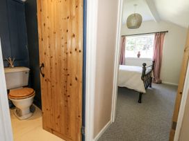 A bathroom with toilet and sink leading to a bedroom at Happiness Cottage in Piddlehinton