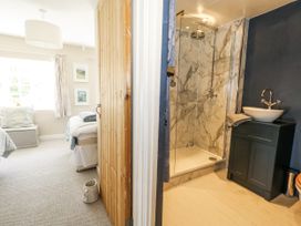 A bedroom with a shower and sink at Happiness Cottage Piddlehinton