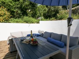 An outdoor seating area with a table and couch at Happiness Cottage in Piddlehinton