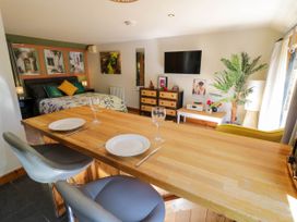 A studio room with a bed dining table chairs a television and a plant at The Pheasant's Nest in Welland near Upton Upon Severn