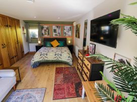 A bedroom with a bed pillows side tables closet wooden dresser and television at The Pheasant's Nest in Welland near Upton Upon Severn