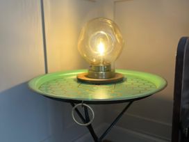 A side table with a lamp in a living room at Craster House in Seahouses