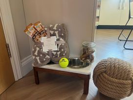 A pet area with a blanket, treats, food bowl and toys at Craster House in Seahouses