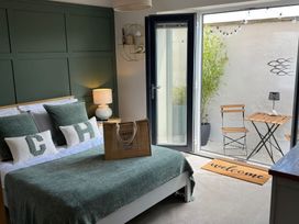 A bedroom with a bed and access to outdoor seating at Craster House in Seahouses