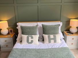 A bedroom with a bed and decorative pillows at Craster House in Seahouses