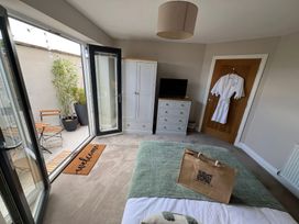 A bedroom with a bed and a door leading to an outdoor area at Craster House in Seahouses