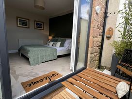 A bedroom with a bed and seating area at Craster House in Seahouses