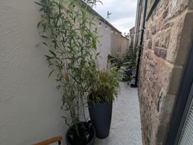 An outdoor pathway with plants and flower pots at Craster House in Seahouses