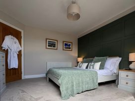 A bedroom with a bed and bedside tables at Craster House Seahouses