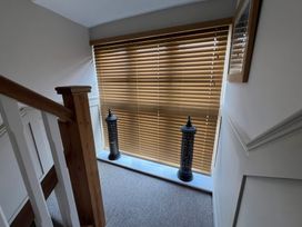 A hallway with decorative lanterns and window blinds at Craster House Seahouses