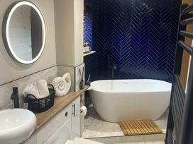 A bathroom with a bathtub and sink at Craster House in Seahouses