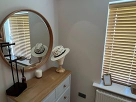 A dressing room with a hat stand and mirror at Craster House Seahouses