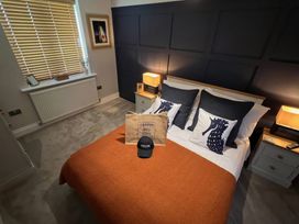 A bedroom with a bed and decorative pillows at Craster House in Seahouses