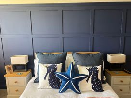 A bedroom with a bed and decorative pillows at Craster House in Seahouses