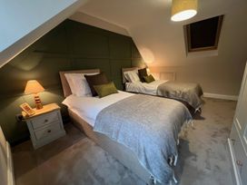A bedroom with two single beds and a lamp at Craster House in Seahouses