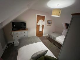 A bedroom with two beds and a television at Craster House in Seahouses