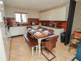 A kitchen with a dining table and chairs at Craster House in Seahouses