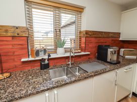 A kitchen with a sink, coffee machine, and speaker at Craster House in Seahouses