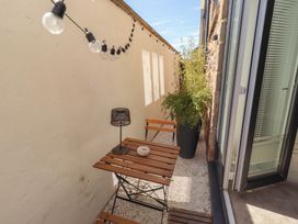 An outdoor seating area with a table and plants at Craster House in Seahouses