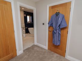 A bathroom entrance with a robe hanging on the door at Craster House in Seahouses