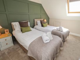 A bedroom with two single beds and a nightstand at Craster House in Seahouses
