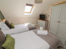 A bedroom with two beds and a television at Craster House in Seahouses