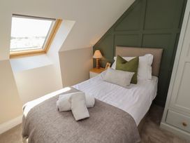 A bedroom with a single bed and window at Craster House in Seahouses