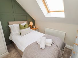A bedroom with a bed and lamp at Craster House in Seahouses