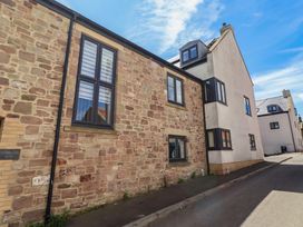 An exterior view of a stone building with windows at Craster House Seahouses