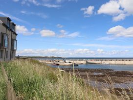 A coastal scene with a harbor and boats at Craster House in Seahouses