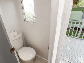 A small bathroom with a toilet and two rolls of toilet paper on top at No 29 Wyndham Hall in Cockermouth