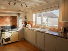 A kitchen with a stove and sink at Rhianfa Newborough