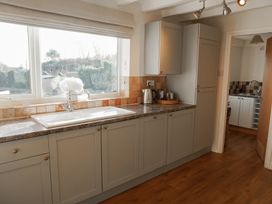 A kitchen with cabinets and sink at Rhianfa Newborough