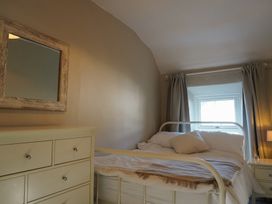 A bedroom with a bed and dresser at Rhianfa in Newborough