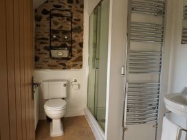 A bathroom with a toilet, shower, and sink at Rhianfa in Newborough