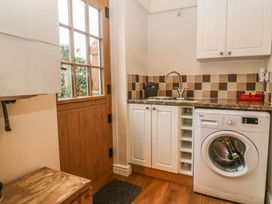 A laundry room with a washing machine and sink at Rhianfa in Newborough