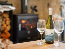 A living room with wine and glasses on a table at Rhianfa in Newborough