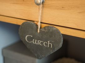 A heart-shaped slate sign hanging from a drawer labelled Cwtch at Rhianfa in Newborough