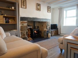 A living room with a fireplace and sofa at Rhianfa in Newborough