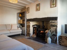 A living room with a fireplace and sofa at Rhianfa in Newborough