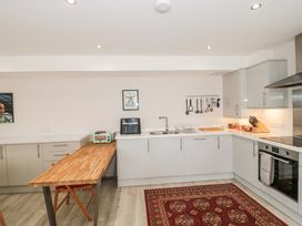 A kitchen with a wooden countertop table a sink cooking utensils and an oven at The Coach House in Castle Cary
