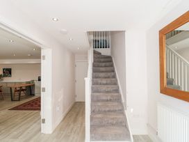 A stairway with grey carpet and a hallway leading to an open room with a table and chairs at The Coach House in Castle Cary