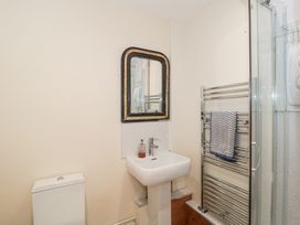 A bathroom with a toilet sink mirror towel rack and glass shower at The Coach House in Castle Cary