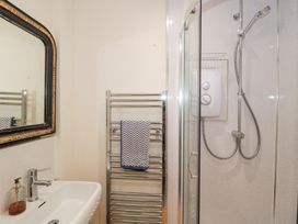 A bathroom with a sink a towel rack with a towel and a shower at The Coach House in Castle Cary