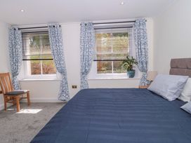A bedroom with a bed and windows at Flat 2 Battledown Grange Cheltenham