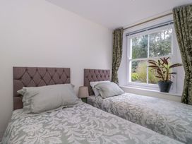 A bedroom with two beds and a plant on the windowsill at Flat 2 Battledown Grange Cheltenham