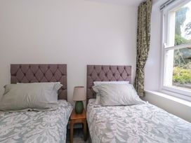 A bedroom with twin beds and a window at Flat 2 Battledown Grange in Cheltenham