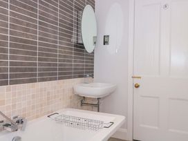 A bathroom with a bathtub and a sink at Flat 2 Battledown Grange Cheltenham